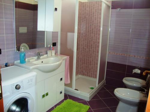 a bathroom with a sink and a washing machine at Casa Vacanze Spadafora in Spadafora