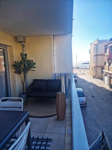- un balcon avec un canapé sur le côté du bâtiment dans l'établissement Apparemment Cosy-Plage 10m- Charme&Confort, au Grau-du-Roi