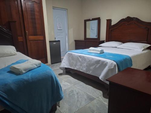 a bedroom with two beds and a mirror at Apartamentos En Edificio Amapola Zona Colonial Malecón in Santo Domingo