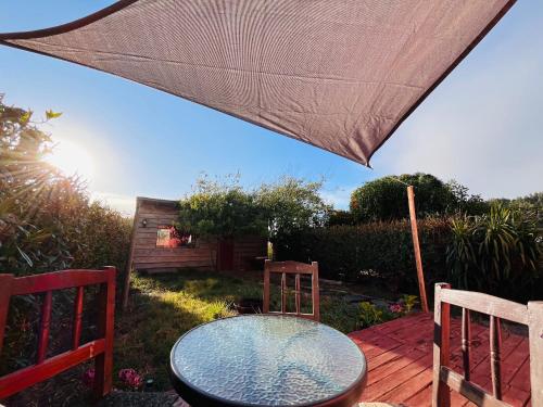 a table and chairs on a deck with an umbrella at Casa Costa Ñuble in Cobquecura