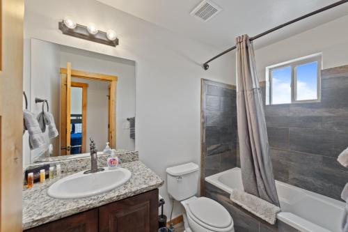 Un baño con lavabo, inodoro y ducha. en Steel Bender Villa, en Moab