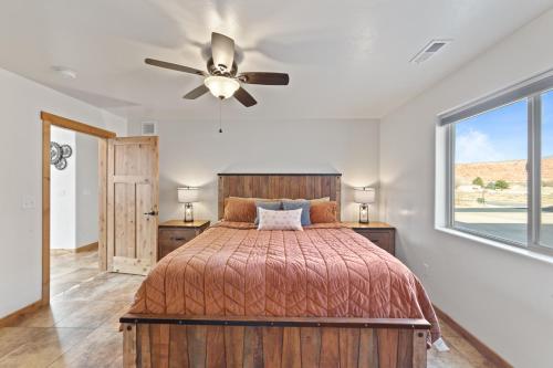 Un dormitorio con una cama y un ventilador de techo. en Steel Bender Villa, en Moab