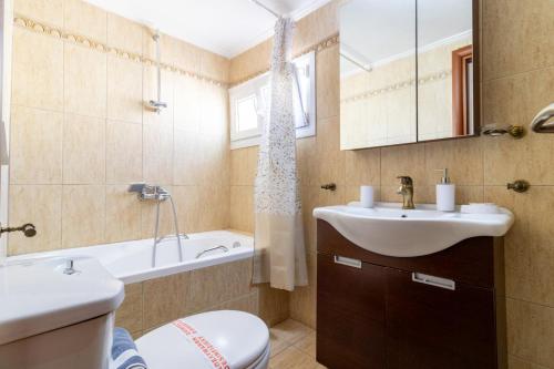 a bathroom with a sink and a toilet and a tub at Dimitra Boutique Apartments 1 in Keramoti