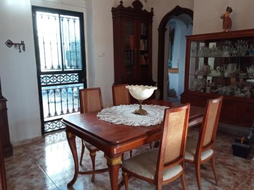 a dining room with a wooden table and chairs at Apartamento Sierra de Grazalema in Prado del Rey