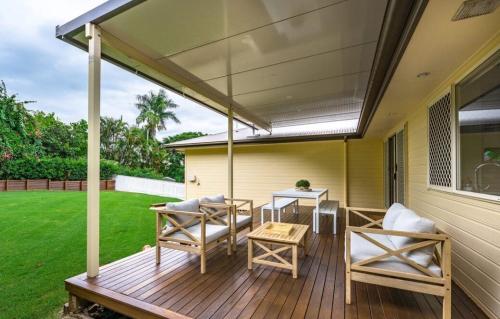 Un patio con toldo y sillas y una mesa. en Lamington Cottage, en The Range