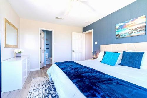 a bedroom with a large bed with blue pillows at Starfish Beachfront Swim-Up in Surfside Beach
