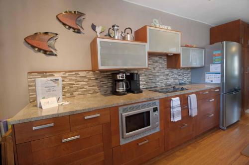a kitchen with wooden cabinets and a stainless steel refrigerator at Folly Ha I in Folly Beach