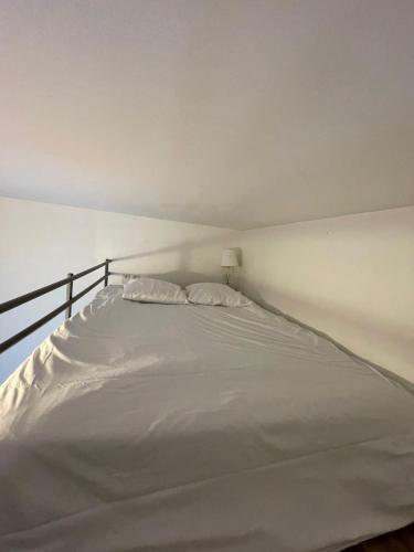 - un lit blanc avec 2 oreillers dans la chambre dans l'établissement Coeur de Bastide, à Bordeaux