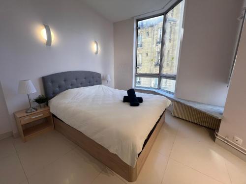 - une chambre dotée d'un lit avec une valise noire dans l'établissement Appartement Tour Eiffel Beaugrenelle Paris, à Paris