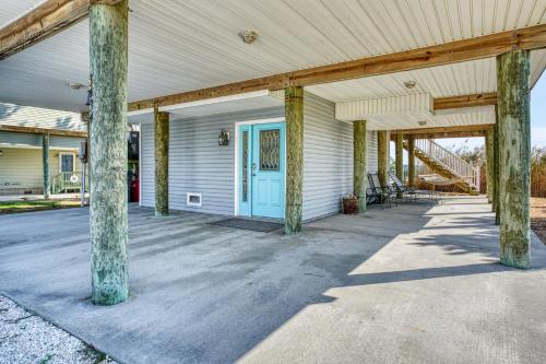 an empty porch with a blue door on a house at Return - Waterfront with boat dock! in Black Point Landing
