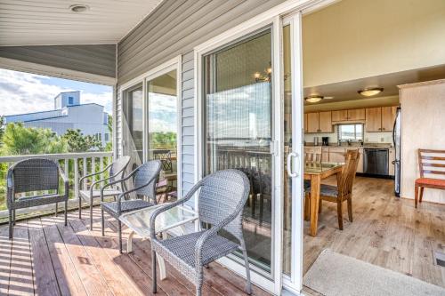 a room with a balcony with chairs and a kitchen at Return - Waterfront with boat dock! in Black Point Landing