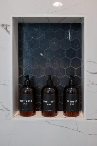three bottles of soap sitting on a shelf in a bathroom at Grand Desert Oasis - SPA - A Location - JT Park in Joshua Tree