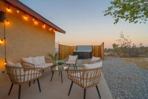 a patio with chairs and a table and a television at Grand Desert Oasis - SPA - A Location - JT Park in Joshua Tree