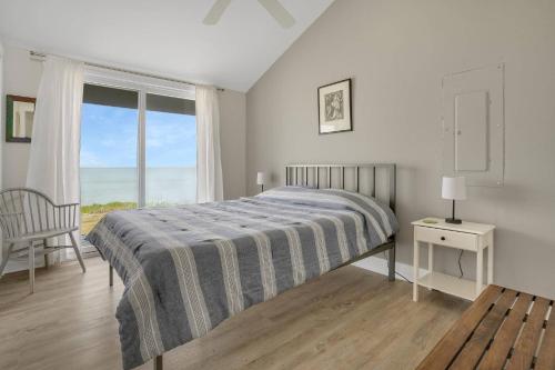 a bedroom with a bed and a large window at Poole's Cove - Waterfront; Main Street! in Deep Hole