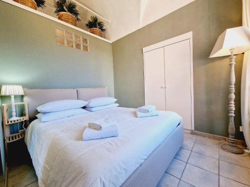 a bedroom with a white bed with towels on it at La Voltellina OLTRE HOME HOLIDAYS in Sanremo