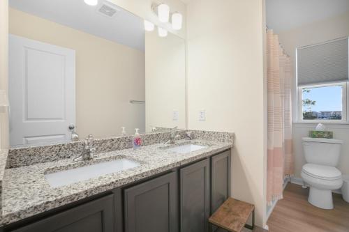 a bathroom with two sinks and a toilet at Robert's Retreat - Brand new home w/ gorgeous water views! in Greenbackville