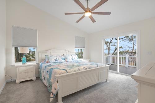 a white bedroom with a bed and a ceiling fan at Robert's Retreat - Brand new home w/ gorgeous water views! in Greenbackville