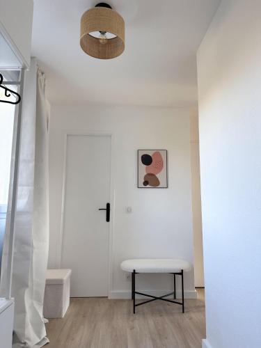 une chambre blanche avec un banc et un plafond dans l'établissement Charmant appartement dans résidence de standing, à La Baule