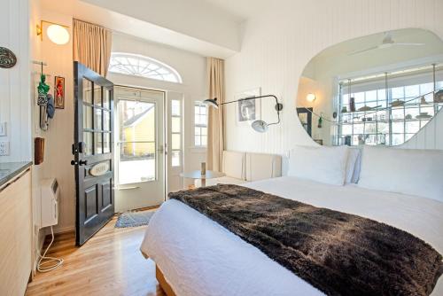 a bedroom with a large white bed and a window at Renovated, Modern Downtown Loft in Provincetown