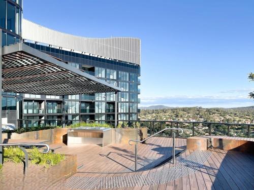 a large glass building with a staircase in front of it at Luxurious Cozy 1-Bed FREE Carpark Gym Pool & Spa in Belconnen