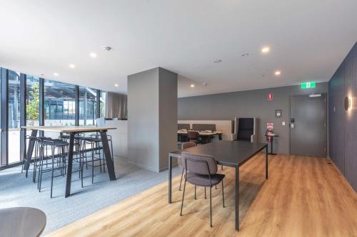 an open living room with tables and chairs at Luxurious Cozy 1-Bed FREE Carpark Gym Pool & Spa in Belconnen