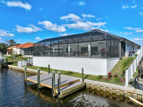a house on the water with a dock at Serene Canal Escape - Heated Pool, Private Dock, Game Room in Palm Coast