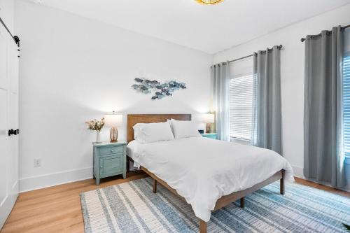 a white bedroom with a bed and a blue nightstand at Serene Canal Escape - Heated Pool, Private Dock, Game Room in Palm Coast