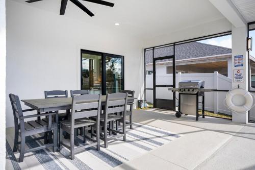 a dining room with a table and chairs and a grill at Serene Canal Escape - Heated Pool, Private Dock, Game Room in Palm Coast