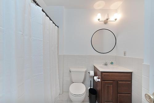 a bathroom with a toilet and a sink and a mirror at Jackson River Estate Studio Apartment on the River in Covington