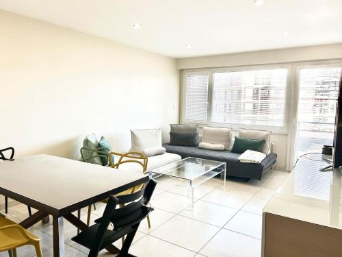 un salon avec un canapé et une table dans l'établissement M45 Marquer Grand T3 centre-ville, à Annemasse