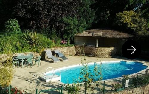 a swimming pool with a table and chairs next to it at Au Mont De La Quintine # Piscine & Jacuzzi # in Saint-Quentin-sur-le-Homme