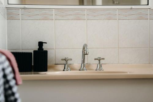 a bathroom sink with two faucets and a mirror at Unit 4, Rocky CBD in Rockhampton