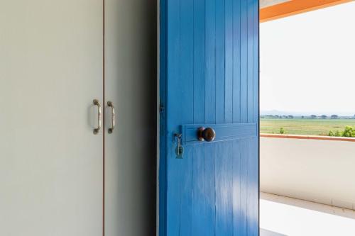 a blue door in a room with a window at Hotel Riva Etrusca in Marina di Bibbona