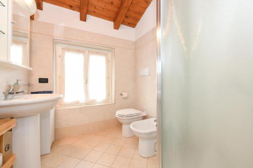 un baño con inodoro y lavabo en Wendy Apartment- Twobedroom & Pool & ParkPrivateFree & Sports, en Desenzano del Garda