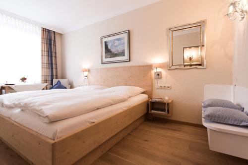 a bedroom with a large bed and a mirror at Hotel Sollner Hof in Munich