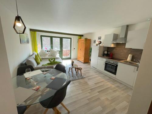 a kitchen and a living room with a table and chairs at Ameisenpfad Todtmoos - Gemütlichkeit und Panorama - Mein SWH in Todtmoos
