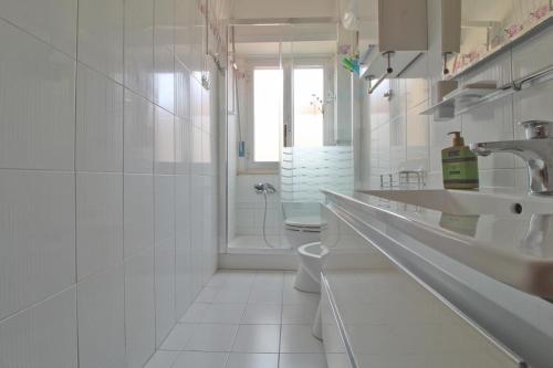 a white bathroom with a toilet and a sink at Appartamento di 60mq in centro sul corso principale "Nazario Sauro" di Giulianova lido ,a 200 m dal mare in Giulianova