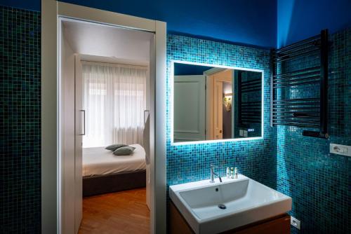 a bathroom with a sink and a mirror and a bed at Sky Blue Rooms in Bastia Umbra