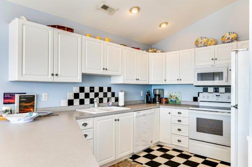 a kitchen with white cabinets and a checkered floor at Steps to Beach Emerald Isle Home with Deck! in Emerald Isle