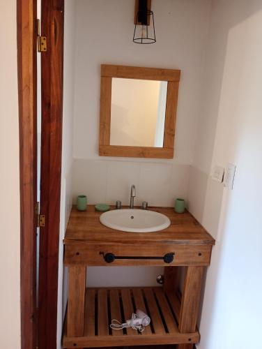 a bathroom with a wooden sink and a mirror at La escondida las siringuillas in Tafí del Valle