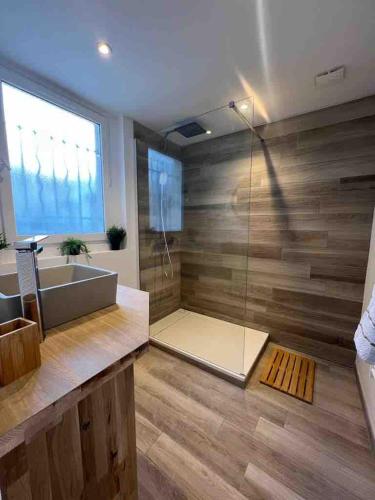 une salle de bain avec baignoire et douche en verre dans l'établissement Reims Cosy Champagne, à Reims