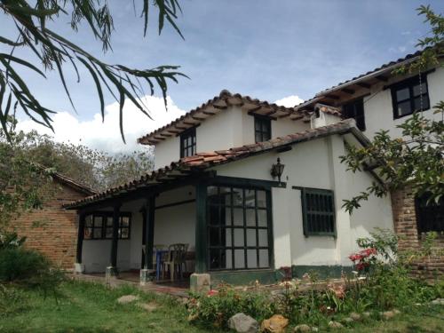 a white house with black windows at DOFA Hosteria in Villa de Leyva