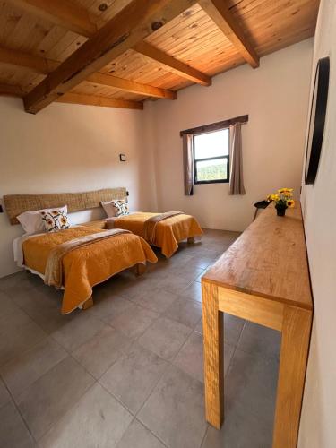 two beds in a room with wooden ceilings at Hotel Tlalcosahua, hotel de Montaña, Tapalpa in Tapalpa