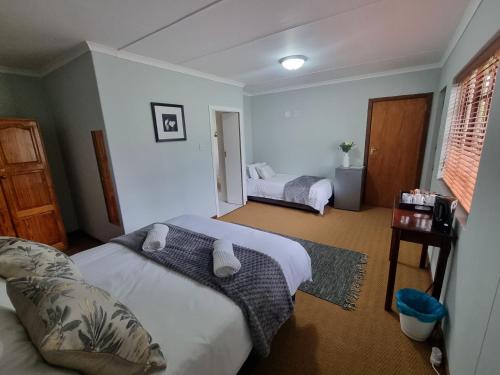 a hotel room with two beds and a window at Farmlands Guesthouse in George