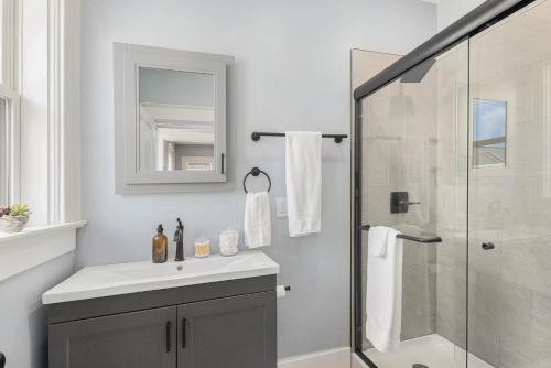 a bathroom with a sink and a glass shower at Remodeled Washer Dryer Mins to Beach & Downtown in Michigan City