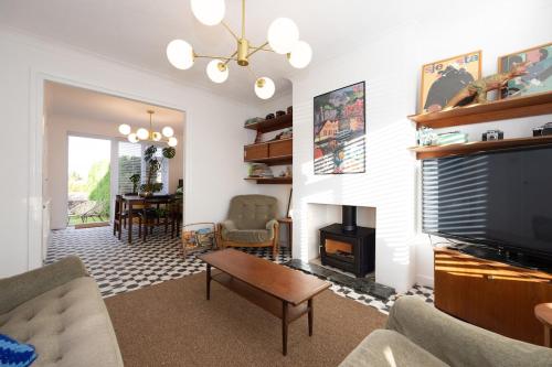 a living room with a tv and a fireplace at Cosy mid century Stockport with views, dog walks, woodburner in Woodley