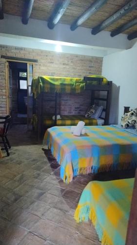 a room with two beds with colorful sheets at DOFA Hosteria in Villa de Leyva