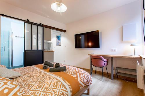 une chambre avec un lit, un bureau et un ordinateur dans l'établissement L'Escapade Hyper-Centre St Aubin, à Toulouse