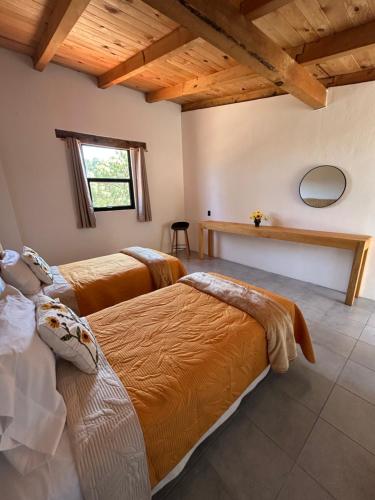two beds in a room with wooden ceilings at Hotel Tlalcosahua, hotel de Montaña, Tapalpa in Tapalpa