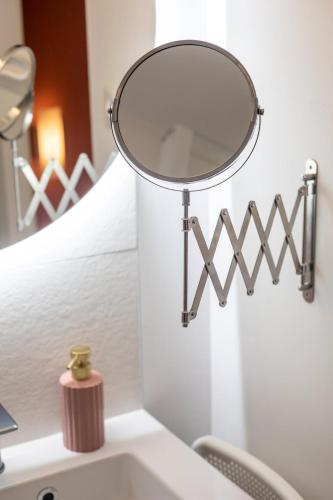 - un miroir au-dessus d'un lavabo dans la salle de bains dans l'établissement L'Escapade Hyper-Centre St Aubin, à Toulouse